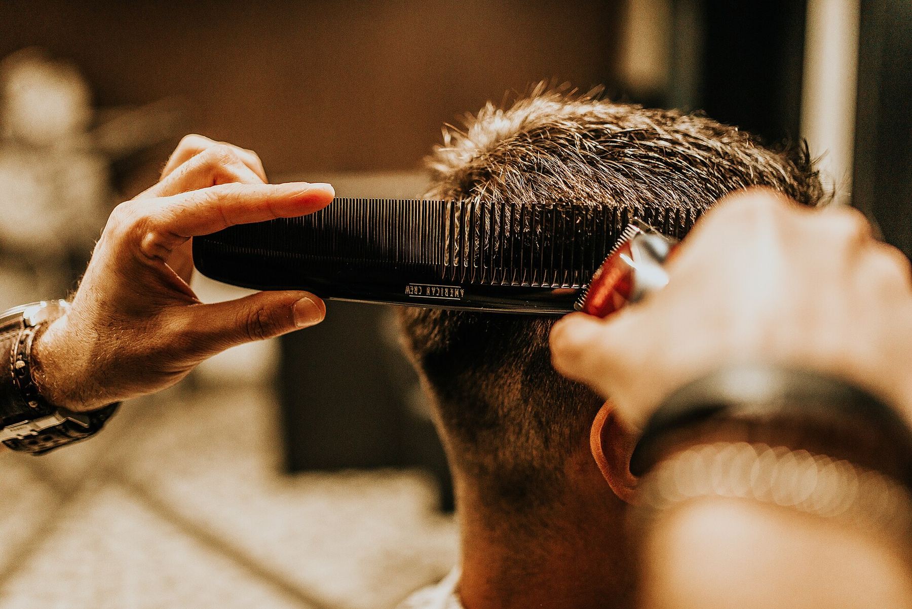Barberis kerpa klientą žirklėmis ir šukomis